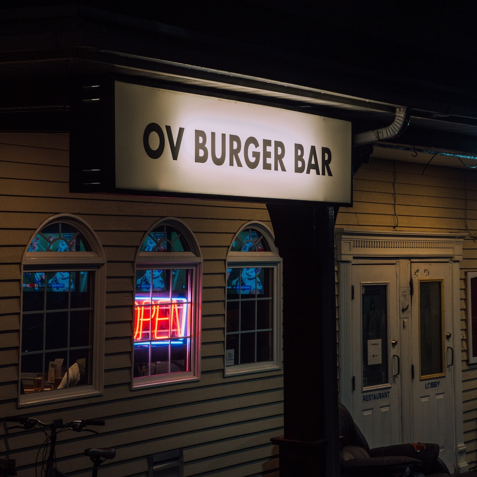 OV Burger Bar exterior sign lit up at night inside the historic Ocean View Hotel in Prince Rupert, BC