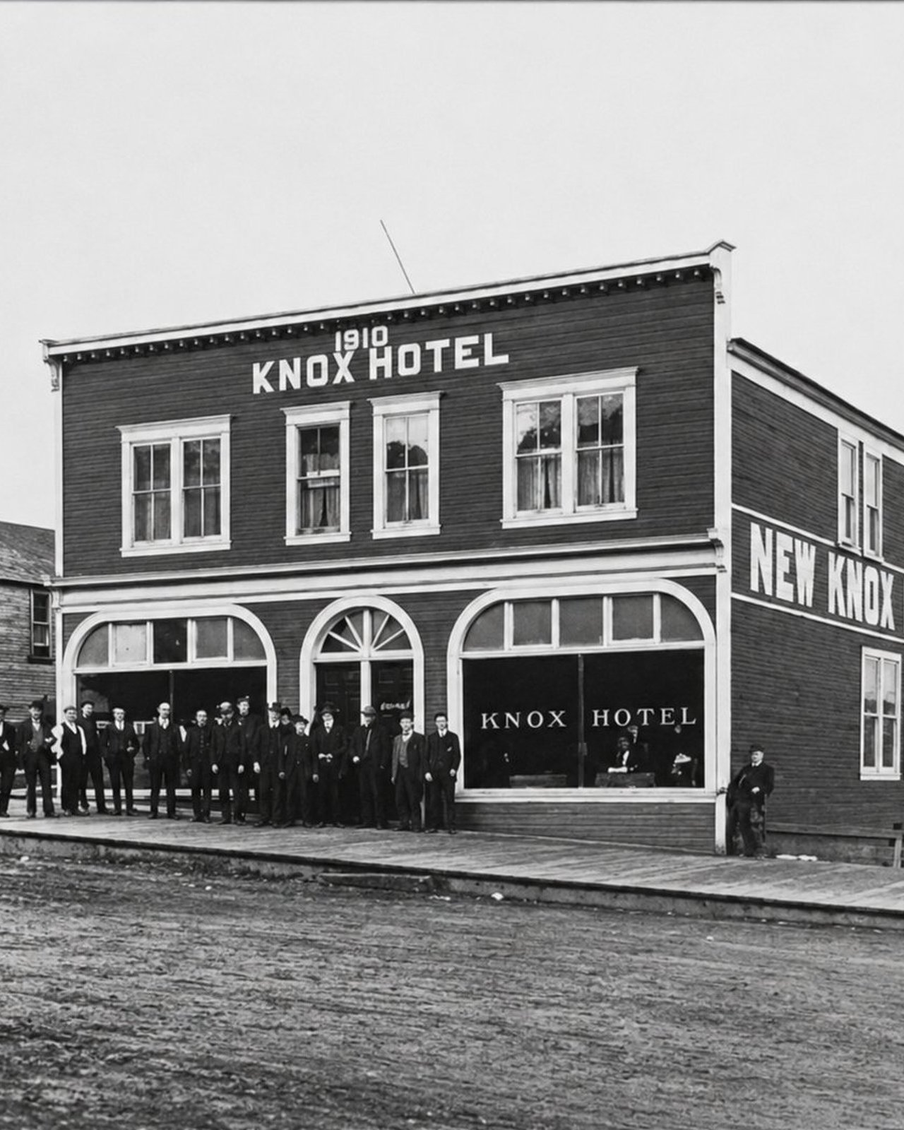 Archival black-and-white photograph of the 1910 Knox Hotel, later the New Knox Hotel, with townspeople gathered out front, the historic building that today houses OV Burger Bar in Prince Rupert, BC
